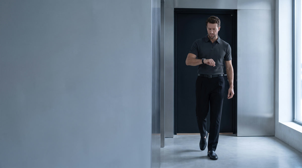 Hombre con polo ELEVAT y pantalón TwistFormal mirando el reloj