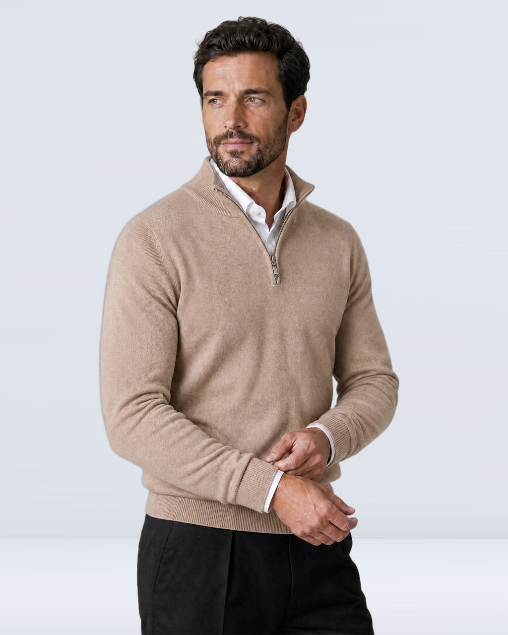 Hombre con suéter WINDSOR beige ajustándose el puño, vista de tres cuartos