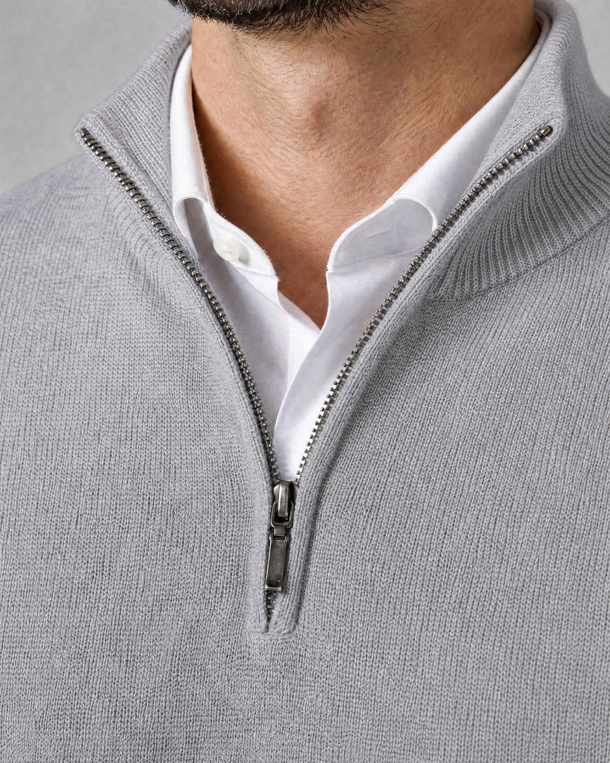 Primer plano del cuello alto, la cremallera y el punto del suéter WINDSOR gris claro