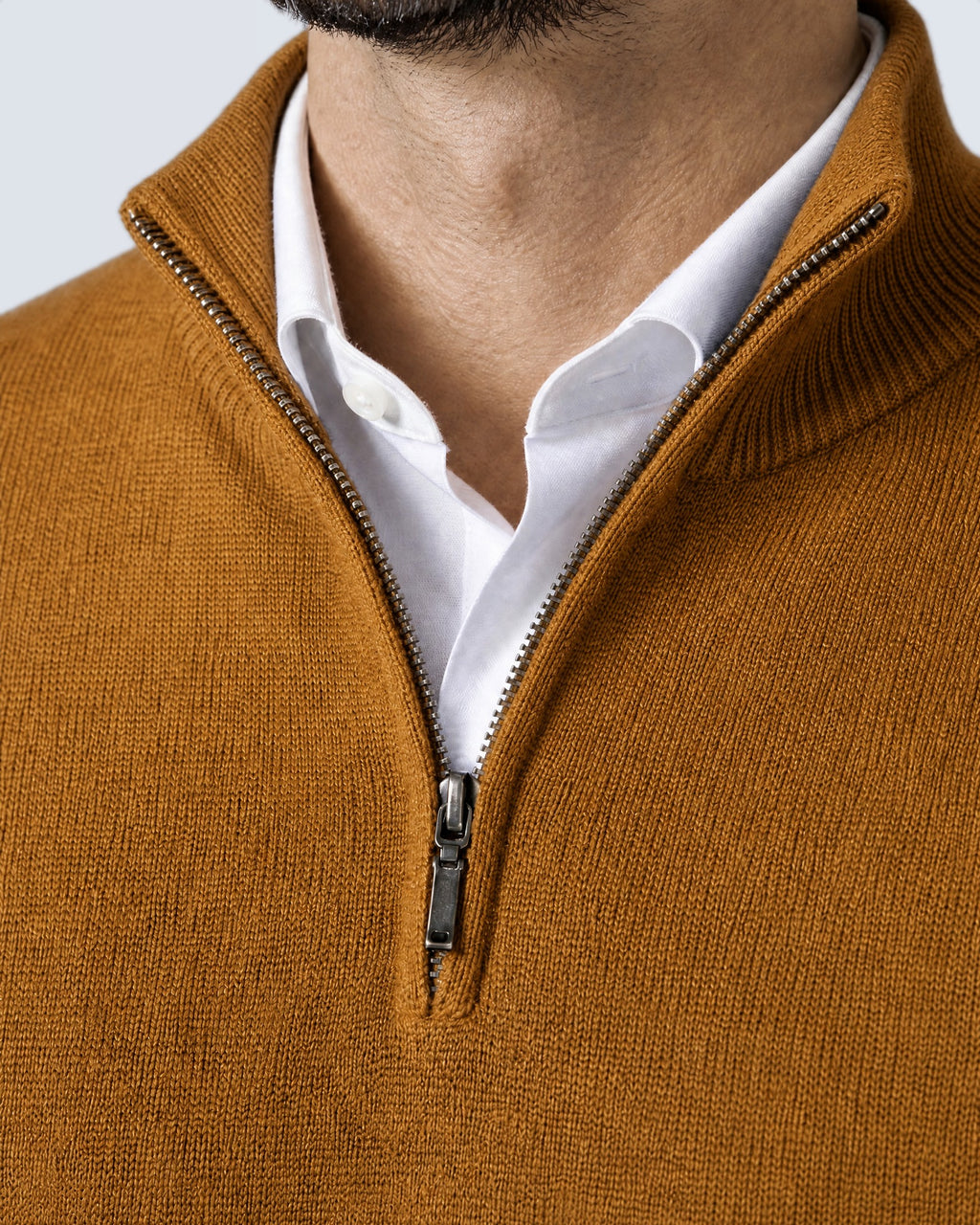 Primer plano del cuello alto, la cremallera y el punto del suéter WINDSOR mostaza