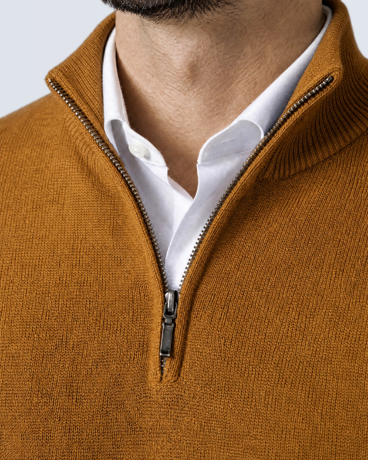 Primer plano del cuello alto, la cremallera y el punto del suéter WINDSOR mostaza
