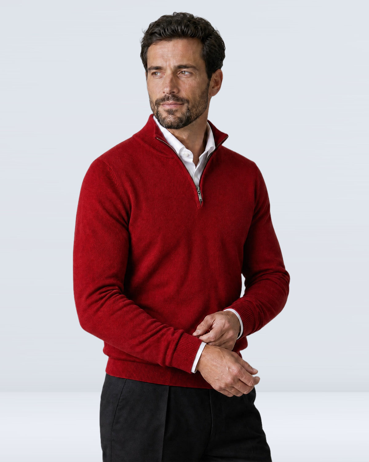 Hombre con suéter WINDSOR rojo ajustándose el puño, vista de tres cuartos