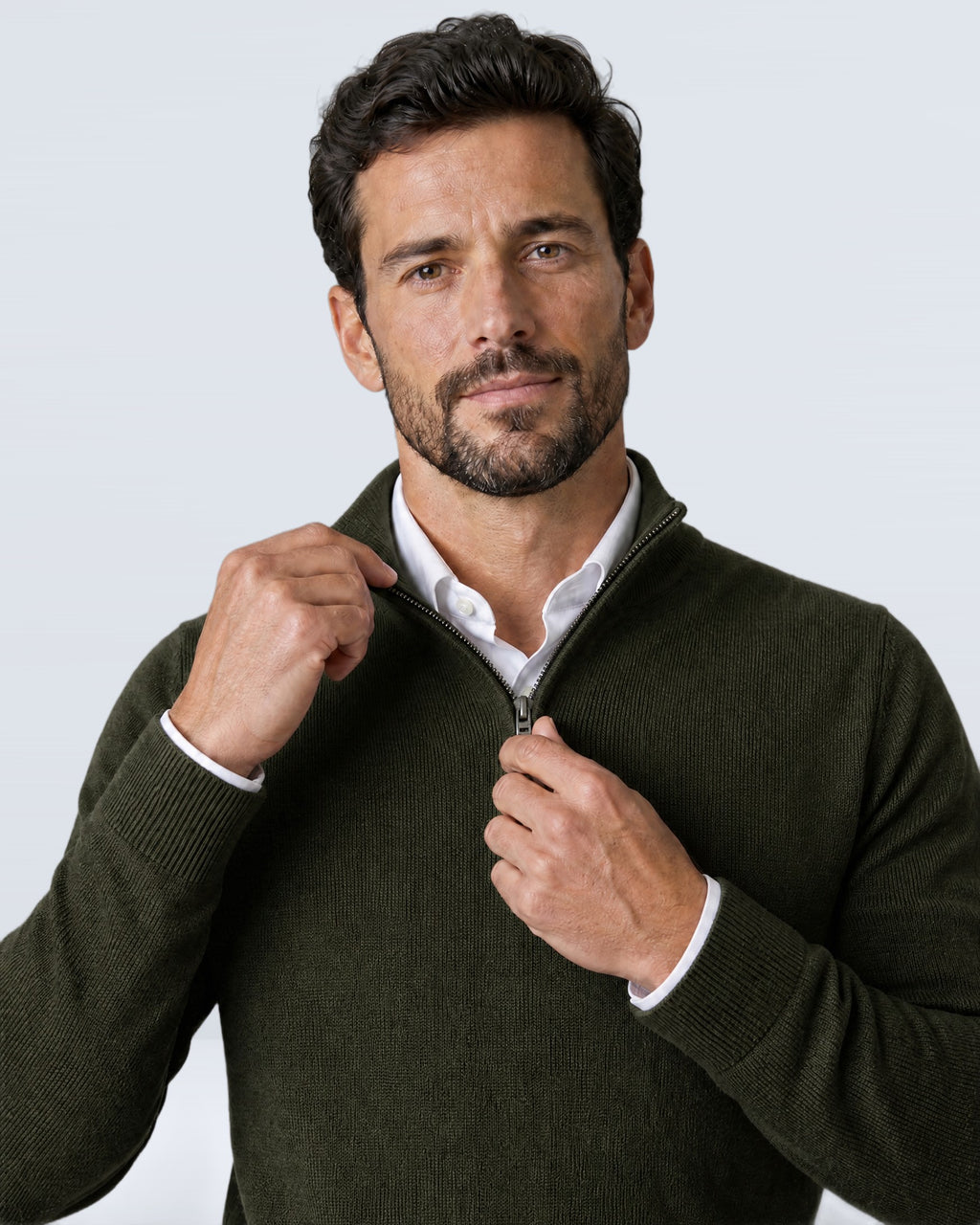 Hombre subiéndose la media cremallera del suéter WINDSOR verde oliva